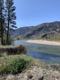 Scenic view of lake and mountains against clear sky