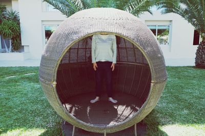 Low section of woman in spherical chair at yard