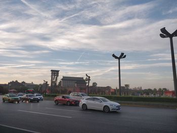 Cars on street in city against sky