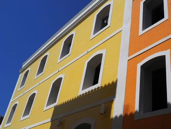 Low angle view of yellow building against sky