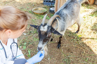 Side view of woman with goat