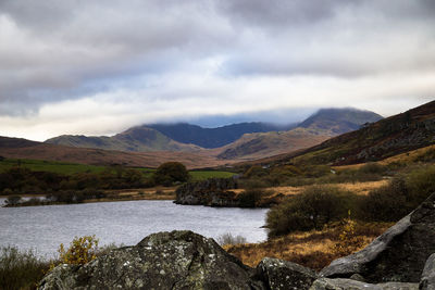 Scenic view of lake by mountains against sky