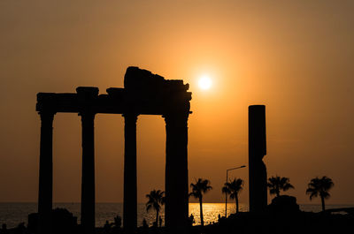 Silhouette built structure against sky during sunset