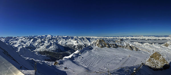 Scenic view of snowcapped mountains against clear blue sky