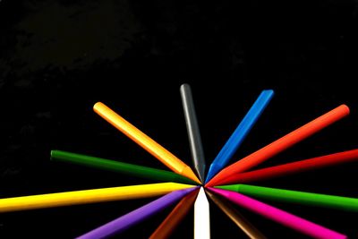Close-up of multi colored pencils over black background
