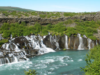 Scenic view of waterfall against sky