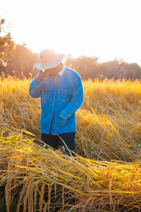 Rear view of man standing on field against sky