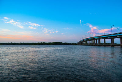 Bridge over river against cloudy sky