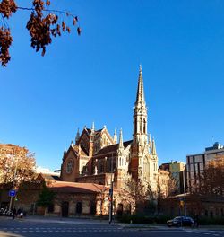 Buildings in city against clear blue sky