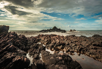 Rocky sea beach with crashing waves at morning from flat angle