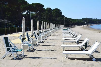 Side view of closed canopies with sun loungers on beach