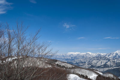 Scenic view of snowcapped mountains against blue sky