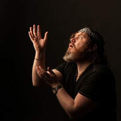 Portrait of man wearing hat against black background