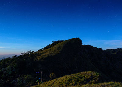 Scenic view of mountains against clear blue sky at night