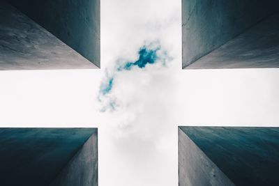 Low angle view of office building against cloudy sky