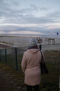 Rear view of man looking at sea against sky