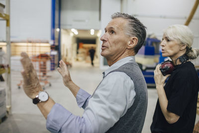 Entrepreneur discussing with female colleague while working at industry