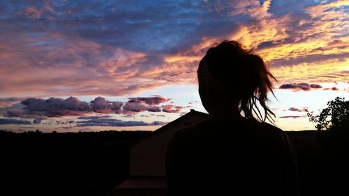 Rear view of silhouette woman standing against sky