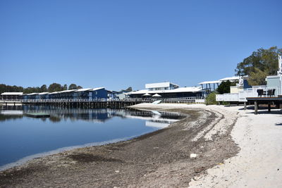 Buildings at beach against clear blue sky