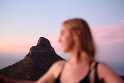 Close-up of woman against mountain during sunset