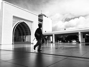 Full length side view of man walking against building