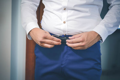 Midsection of man wearing belt