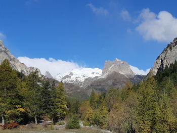 Scenic view of snowcapped mountains against blue sky