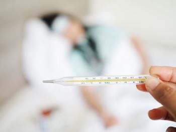 Cropped hand of doctor holding thermometer