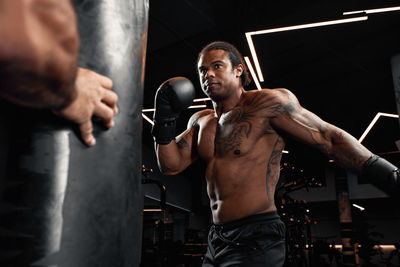 Midsection of man exercising in gym