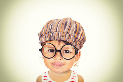 Portrait of boy wearing mask against white background