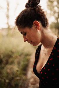 Close-up portrait of young woman looking away outdoors