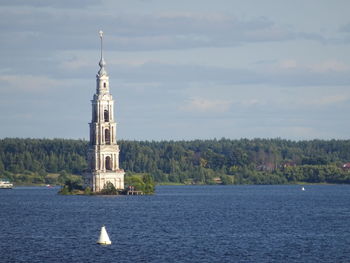 White building by sea against sky