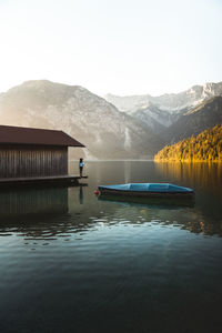 Traveler young woman relaxing on pier and looking at view in plansee lake, tirol, austria