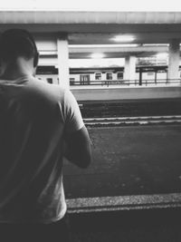 Rear view of woman standing on railroad station platform