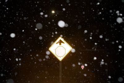 Close-up of illuminated road sign during winter