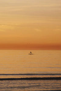 Scenic view of sea against orange sky