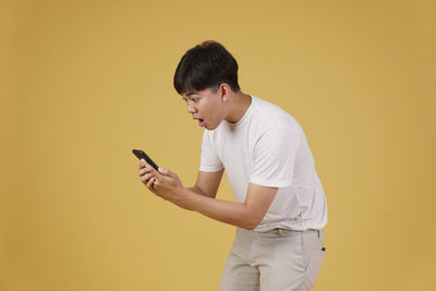 Full length of boy using mobile phone