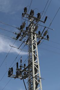 Low angle view of electricity pylon against sky