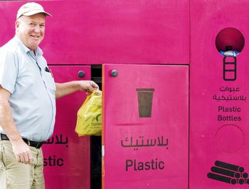 Full length of man standing against pink wall