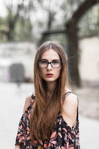 Young brown-haired millennial with glasses and light dress