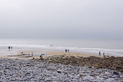 People at beach against sky