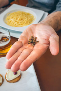 Cropped hand of man holding worms at restaurant