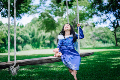 Full length of smiling young woman in park