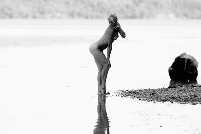 Naked woman posing in lake