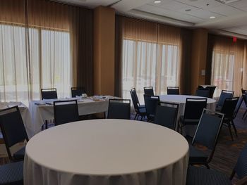 Empty chairs and tables arranged in conference room