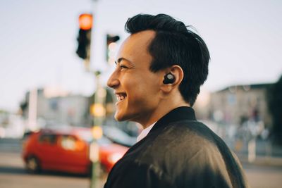 Portrait of young man looking away in city