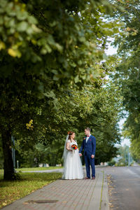 Bride and groom standing at park