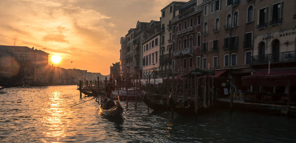 View of boats in canal at sunset