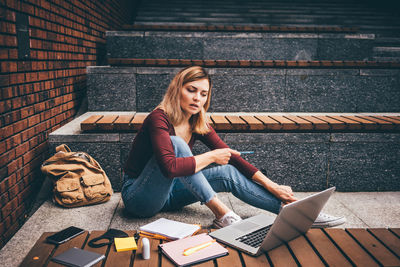 Low angle view of woman sitting on staircase