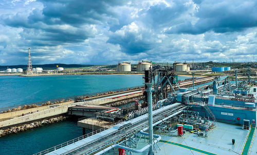 Lpg cargo ship docked in the port. view from the deck of the ship to the shore and gas tanks.